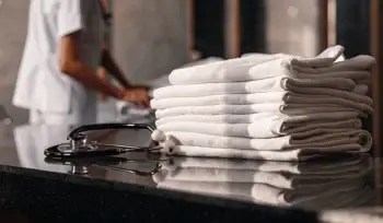 Clean, folded healthcare linens and a stethoscope.