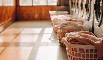 Baskets of clean clothes in front of modern machines at the best laundromat in Bayville.