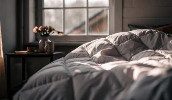 A freshly cleaned comforter on a bed from a professional cleaning service in Commack.