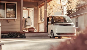 Laundry pickup service van collecting laundry from a front porch in Garden City.