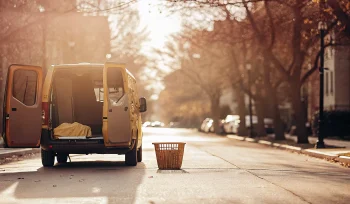 A laundry pickup service van collecting a basket of laundry in Upper Brookville.