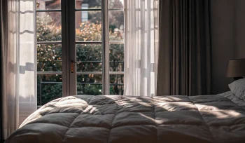 A bright, clean comforter after professional cleaning in a Garden City bedroom.